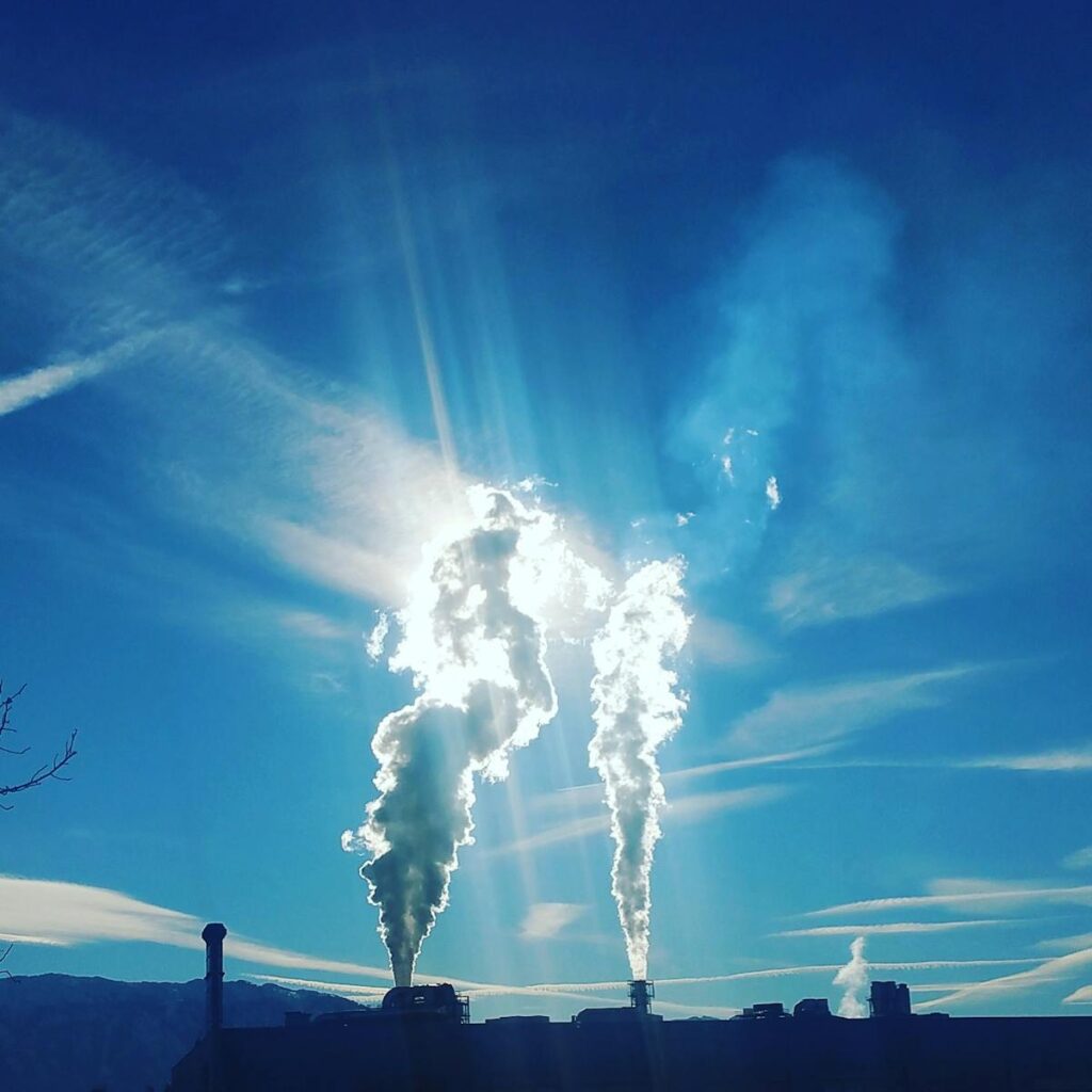 Chaminés industriais emitindo fumaça para ilustrar emissões que entram na lógica do mercado de carbono