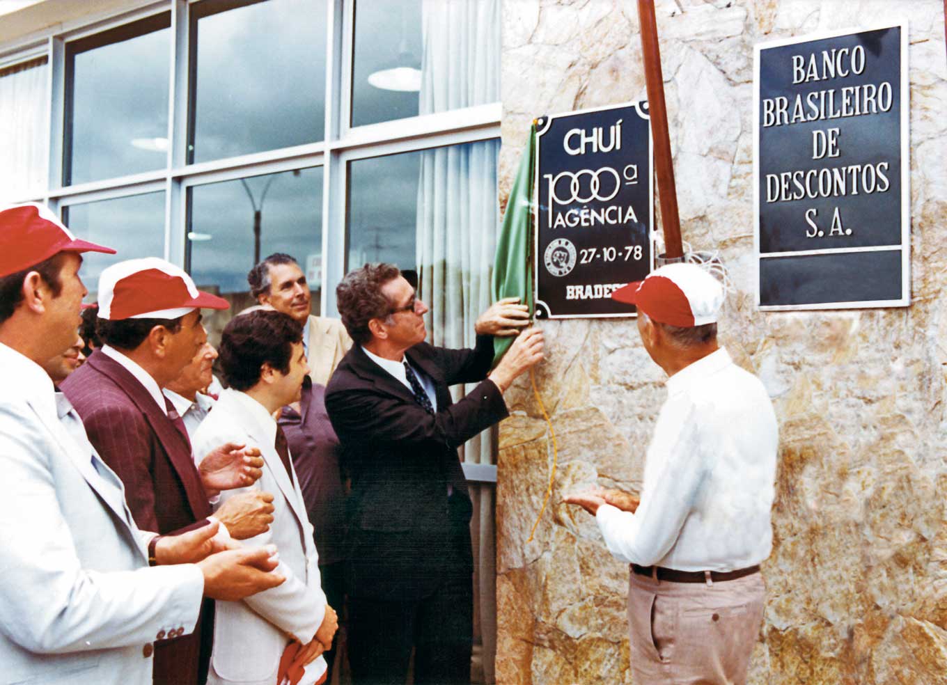 Bradesco: a história do maior banco privado do Brasil 3 Amador Aguiar inaugura a 1.000ª agência do Bradesco na cidade de Chuí (RS), com público presente e faixa comemorativa — marco histórico da expansão nacional do banco
