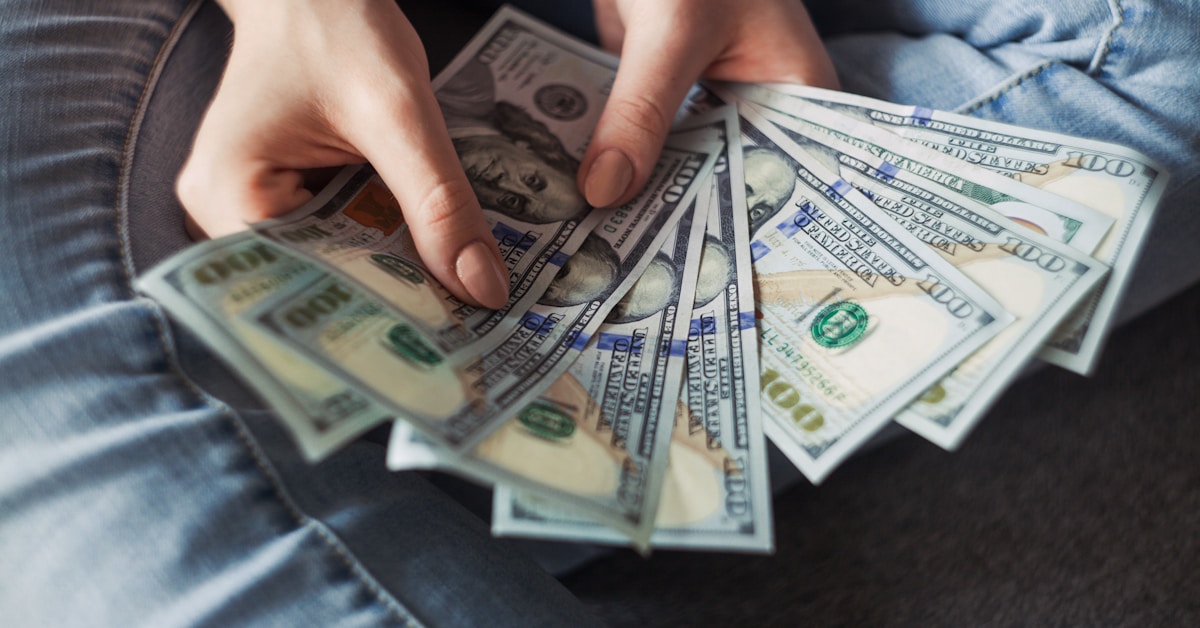 FGTS Aniversário — simulação de saque anual e comparação de rentabilidade Simulação FGTS Aniversário com empilhamento de moedas representando saldo do FGTS e valor disponível para saque anual
