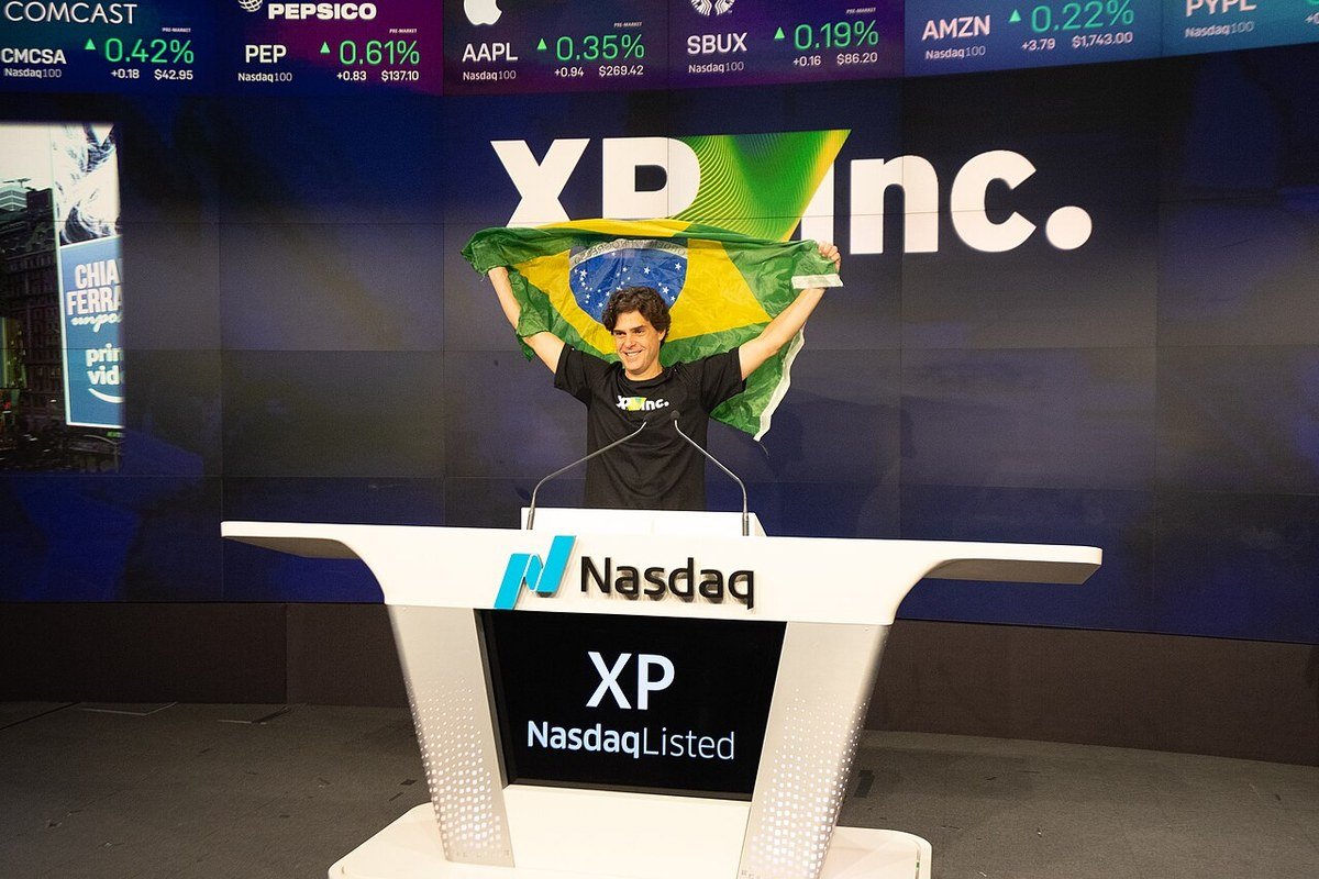 XP: a história da corretora que virou gigante 2 Guilherme Benchimol segura uma bandeira do Brasil durante a cerimônia de IPO da XP Inc. na Nasdaq, em Nova York
