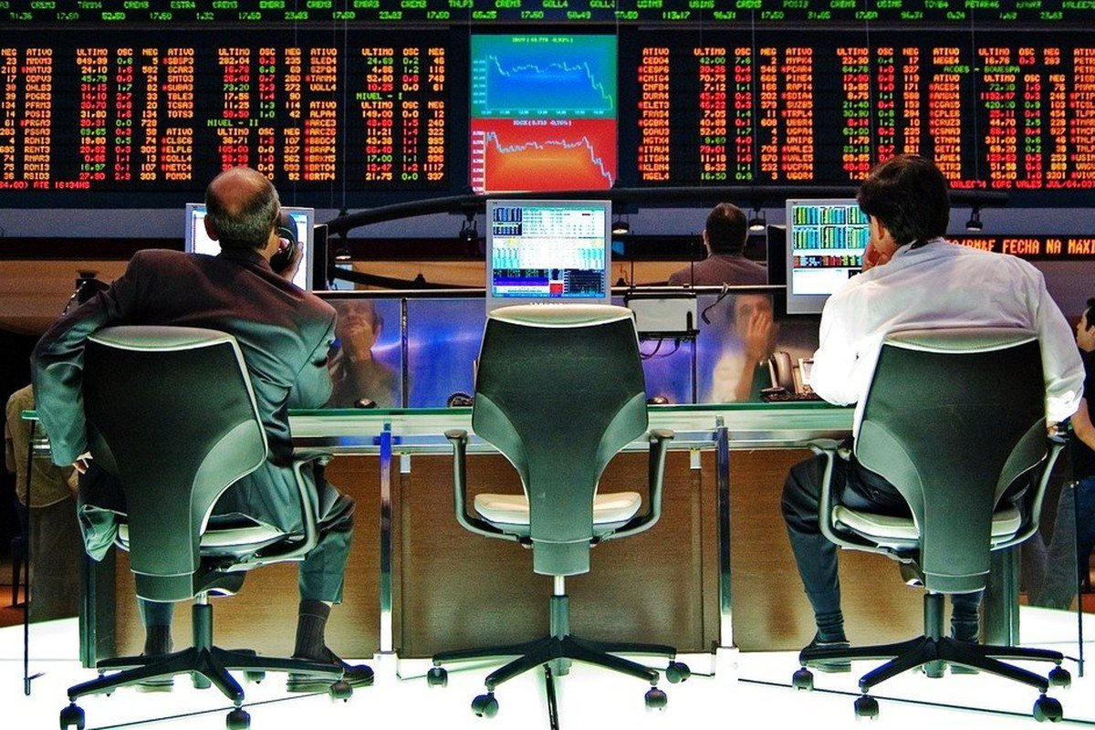 Operadores acompanhando painel de cotações em pregão da B3, ilustrando a queda das ações da GOL e o processo de fechamento de capital
