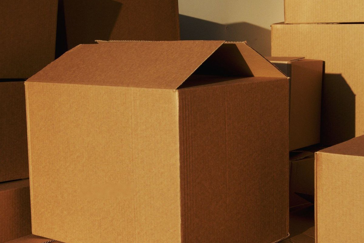 Pilha de caixas de papelão em centro de distribuição, ilustrando a operação logística por trás do e-commerce