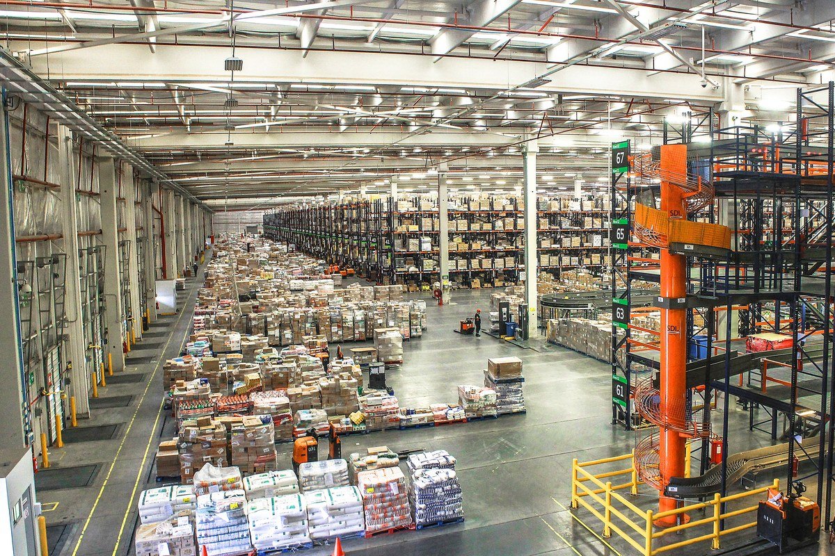 Interior de galpão logístico moderno com prateleiras industriais e paletes organizados, tipo de imóvel comum na carteira de FIIs de tijolo do segmento logístico