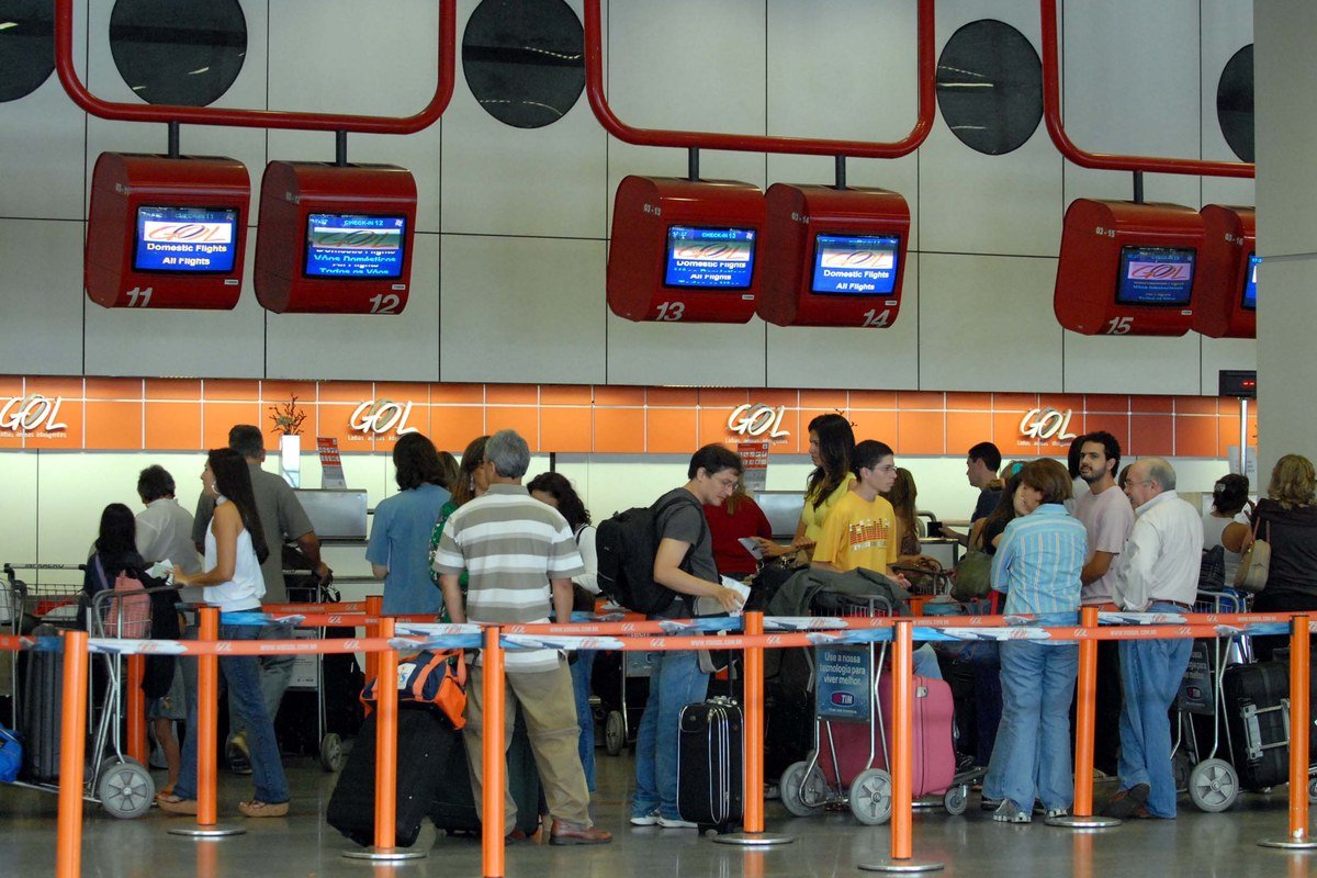 Balcão de check-in da GOL em aeroporto com passageiros na fila, ilustrando a popularização das viagens aéreas no Brasil a partir de 2001