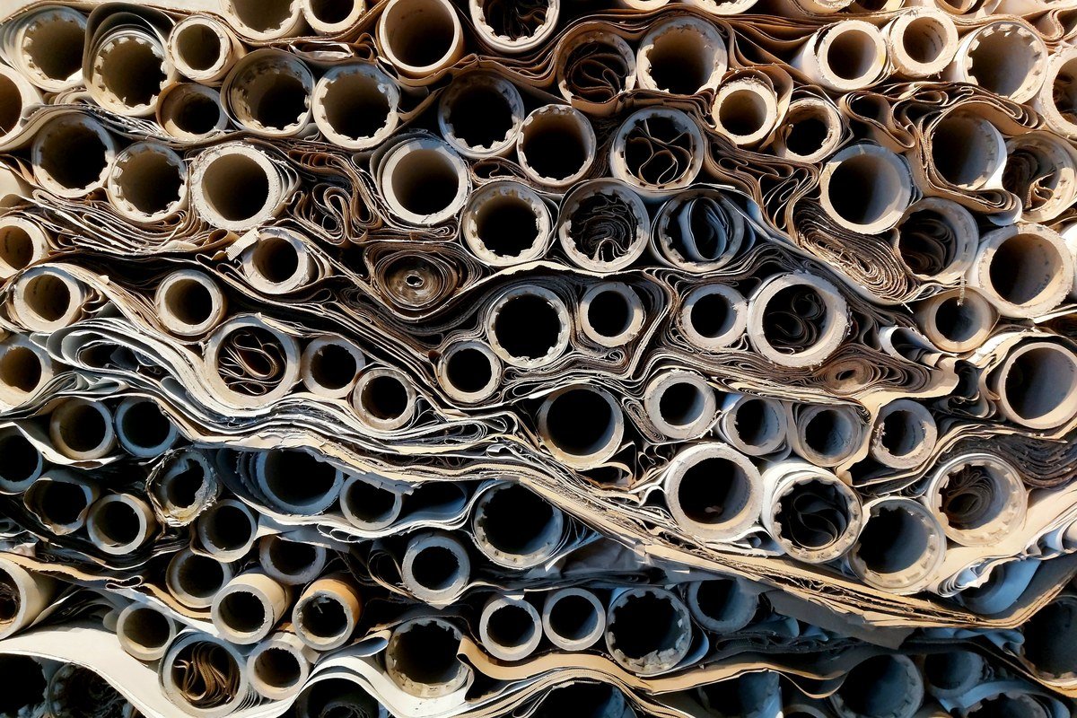 A Suzano nasceu como uma pequena fábrica de papel em São Paulo Rolos de papel empilhados numa fábrica, ilustrando a origem da Suzano como empresa produtora de papel