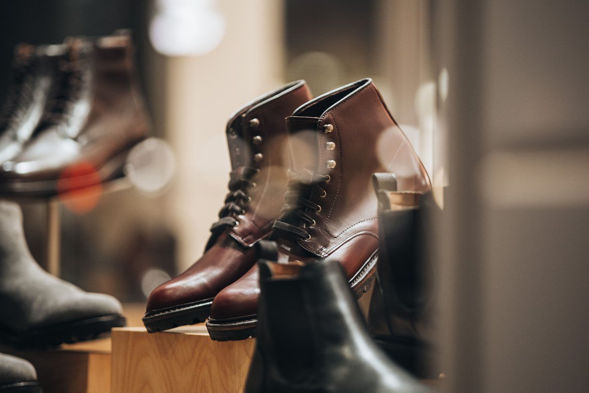 Vitrine de loja com botas de couro femininas em exposição, ilustrando a expansão da Arezzo&Co no varejo de calçados após o IPO de 2011
