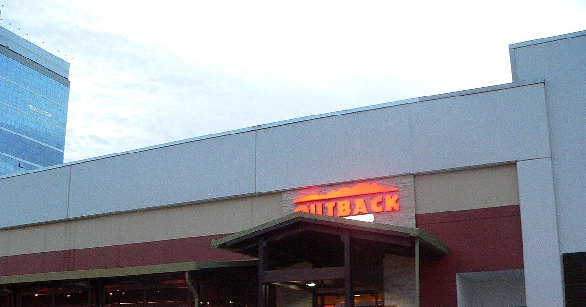 Fachada de uma loja Outback em Tamboré, Barueri, com o letreiro 'OUTBACK' iluminado
