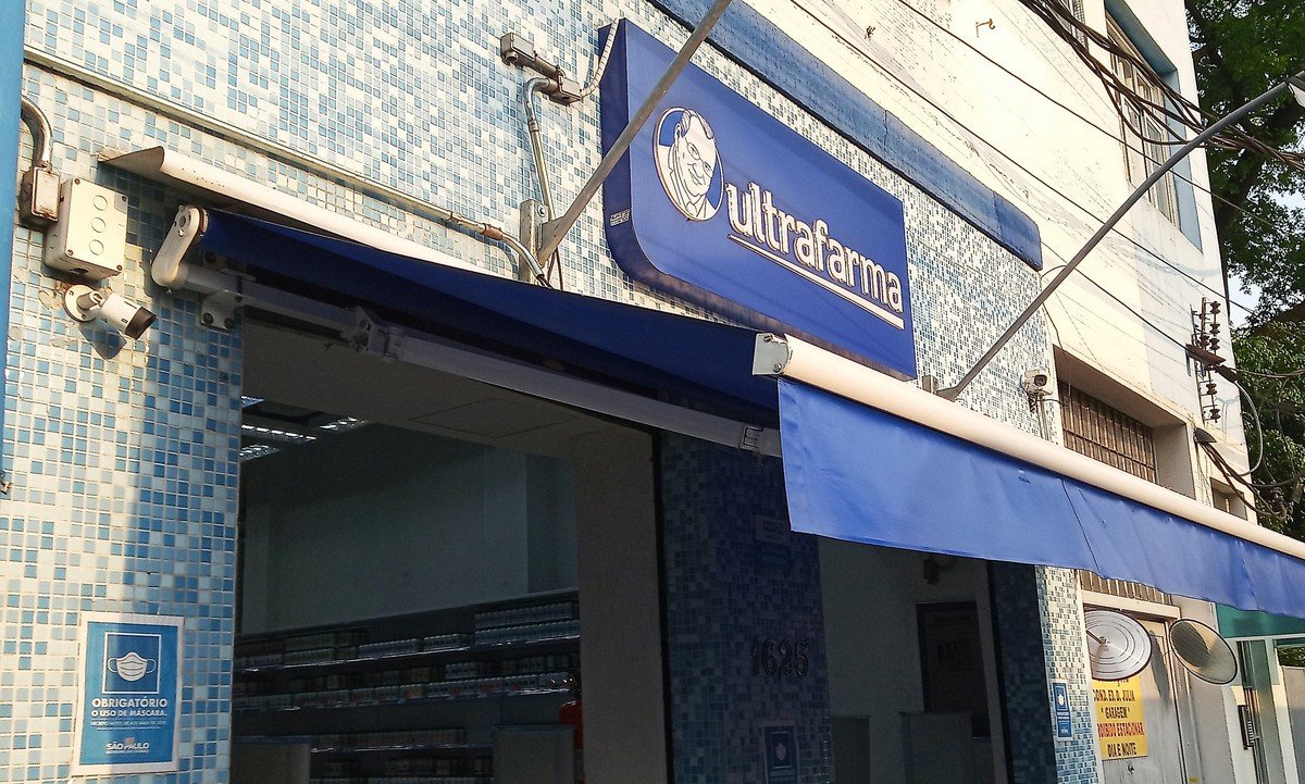 Fachada de uma loja Ultrafarma com o logo da marca e a caricatura do fundador Sidney Oliveira no letreiro
