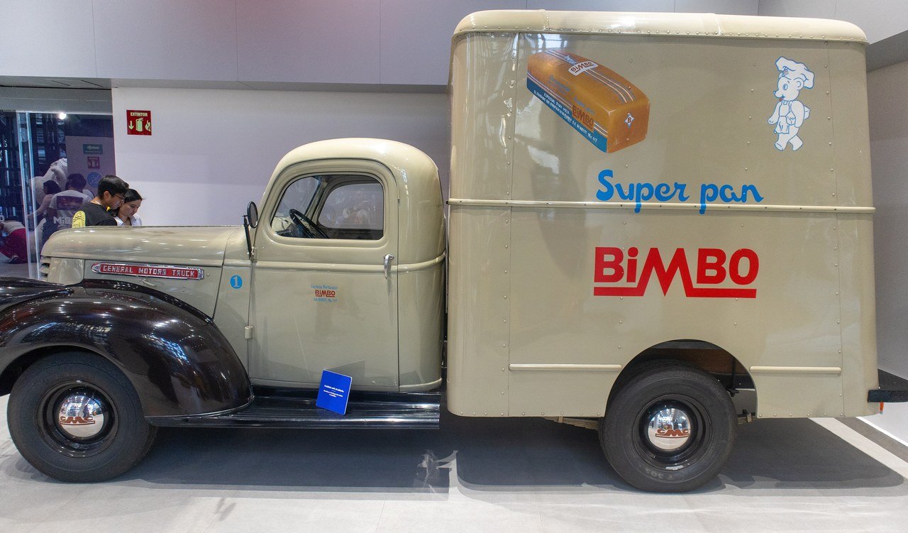 Caminhão de entregas bege dos anos 1950 com a marca Bimbo e a inscrição Super pan, exposto em museu