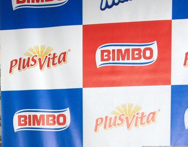 Painel com os logotipos Bimbo e Plus Vita em quadros azuis, brancos e vermelhos