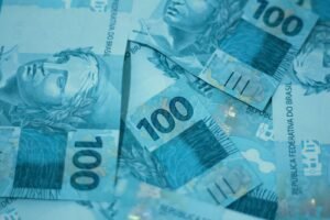 Notas brasileiras de cem reais ilustram a proteção de depósitos e investimentos pelo FGC