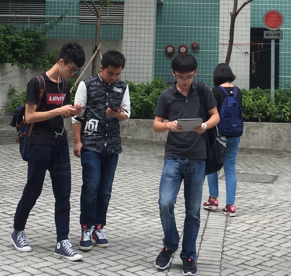 China regula IA de companhia: por que chatbots que imitam relações humanas viraram alvo 3 Jovens caminhando na rua enquanto usam smartphones