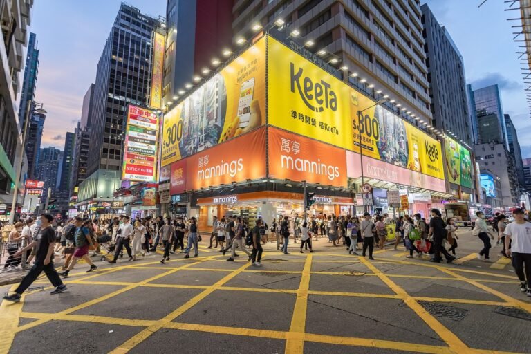 Painel amarelo da Keeta em um cruzamento movimentado de Hong Kong