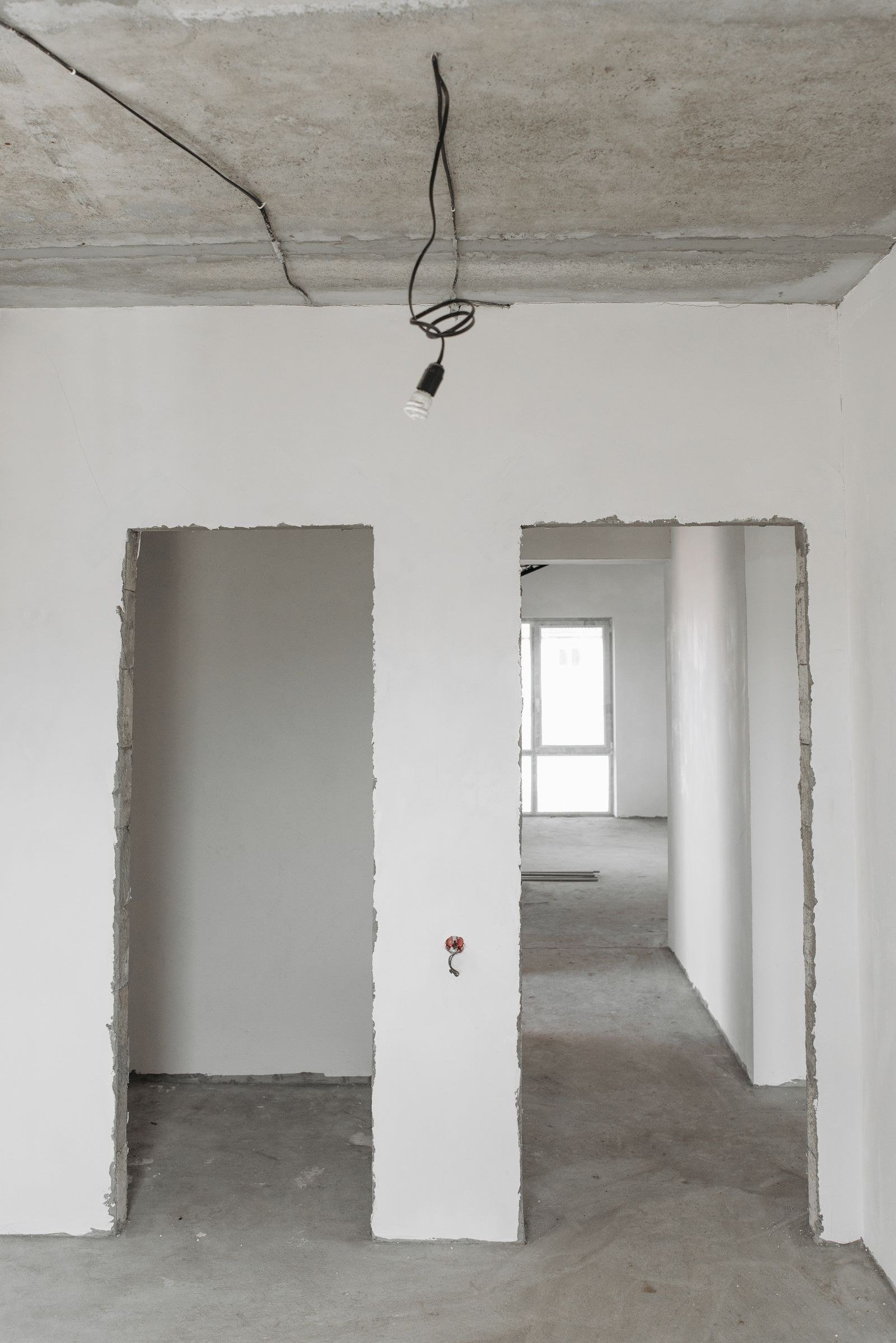 Leilão de imóveis: como funciona, riscos e custos antes de dar o lance 5 Apartamento vazio em obra, com paredes sem acabamento e fios expostos