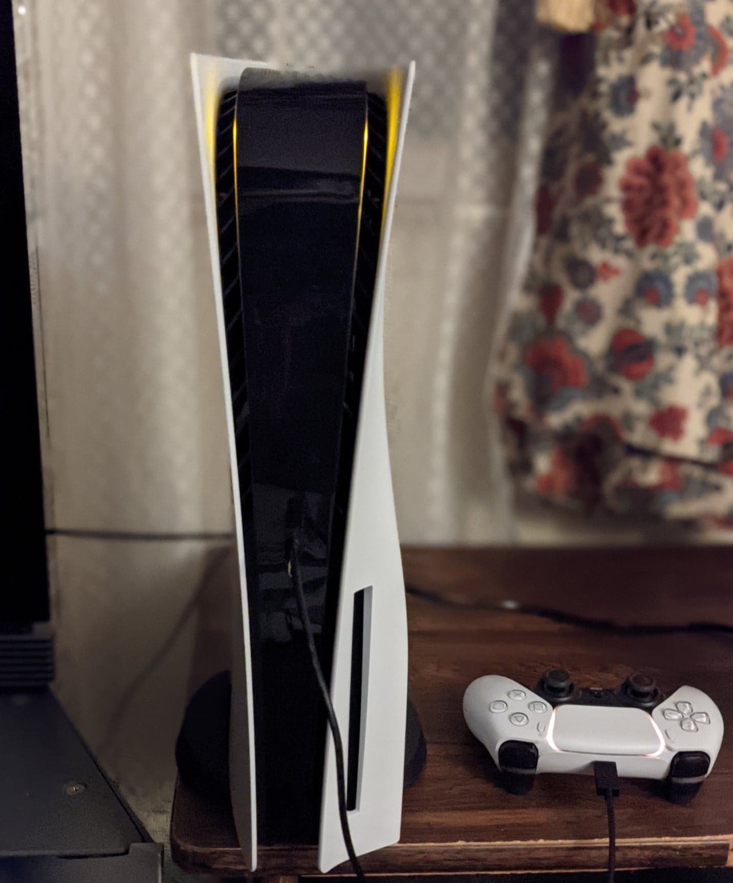PlayStation 5 na vertical, com o controle DualSense. O console foi lançado em novembro de 2020.