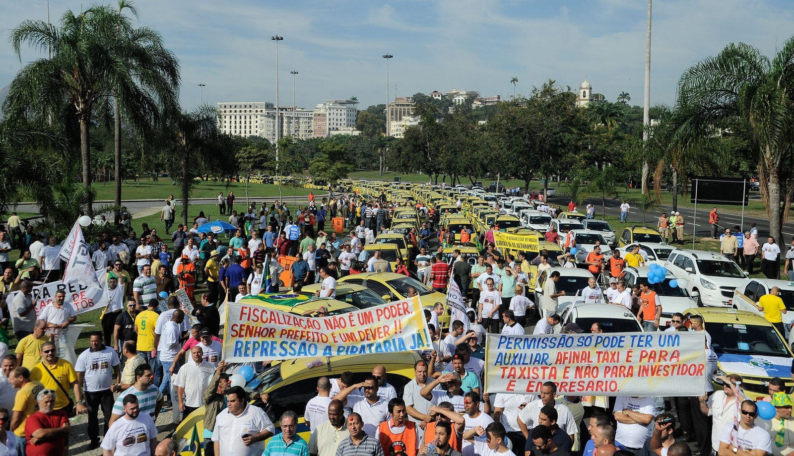Quem é o dono da Uber? A história da empresa americana e as curiosidades do app no Brasil e no mundo 7 Multidão de taxistas com faixas e táxis amarelos em uma avenida do Rio de Janeiro durante protesto contra o aplicativo Uber
