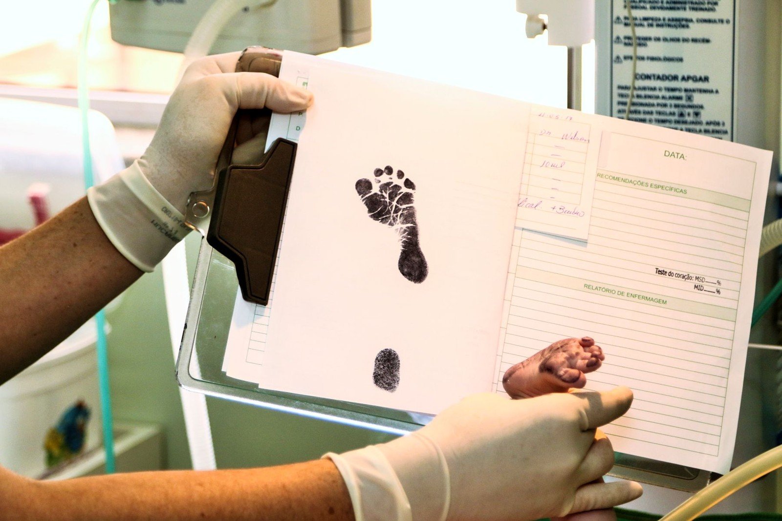 Salário-maternidade: quem tem direito, inclusive desempregadas e MEIs 6 Profissional de saúde registra o pezinho de um recém-nascido em ficha. Foto ilustrativa para a seção de documentos.
