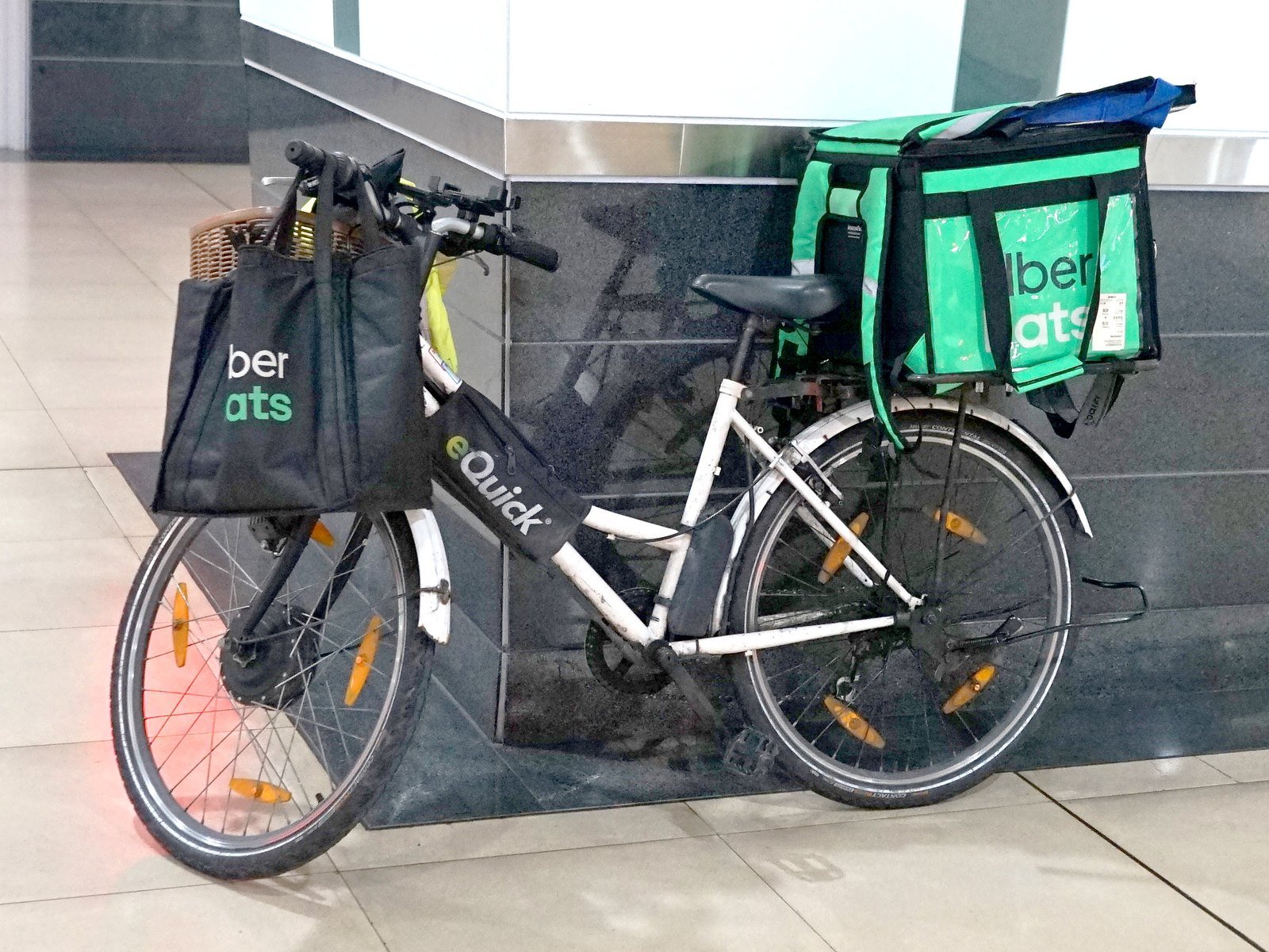 Quem é o dono da Uber? A história da empresa americana e as curiosidades do app no Brasil e no mundo 6 Bicicleta com bolsas térmicas verdes e pretas do Uber Eats estacionada no saguão de uma estação de trem em Taipé